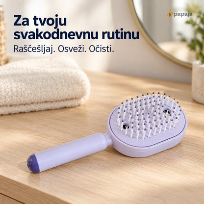 Svetloljubičasta četka za kosu na stolu pored peškira za svakodnevnu negu